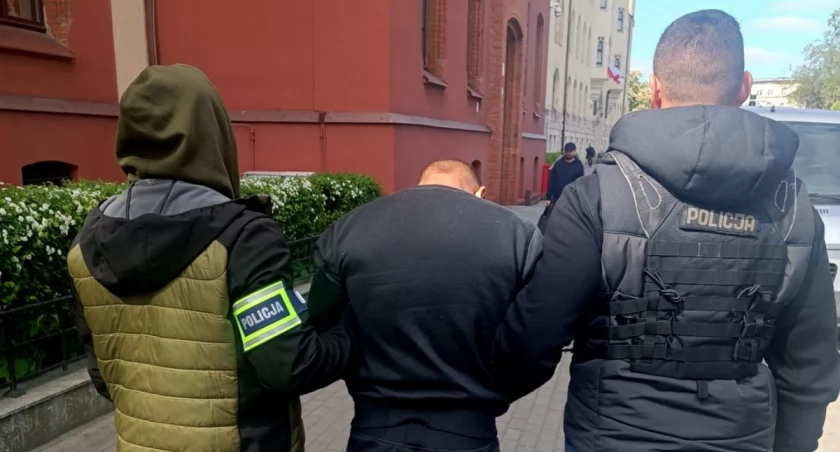 Zatrzymany prowadzony w kajdankach przez dwóch funkcjonariuszy po brutalnym ataku w Solcu Kujawskim.
