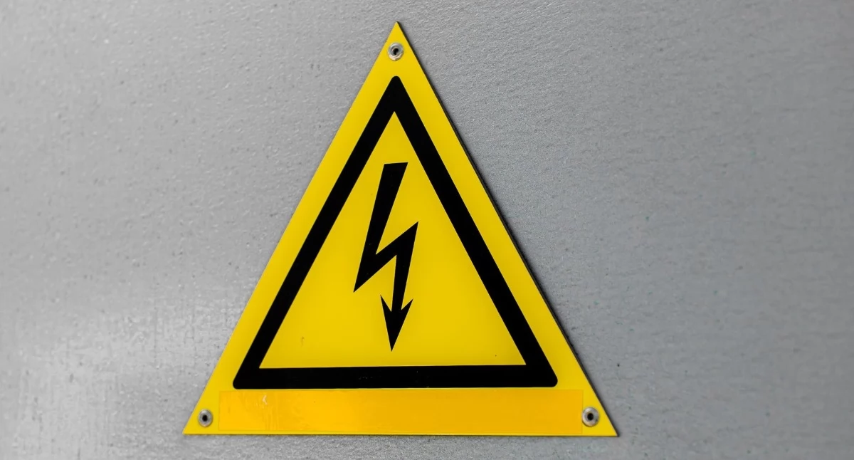 Zdjęcie ilustracyjne: zbliżenie żółtego znaku ostrzegawczego wysokiego napięcia na ścianie. wymiana liczników energii. Fot. Anastasiya Badun / Pexels